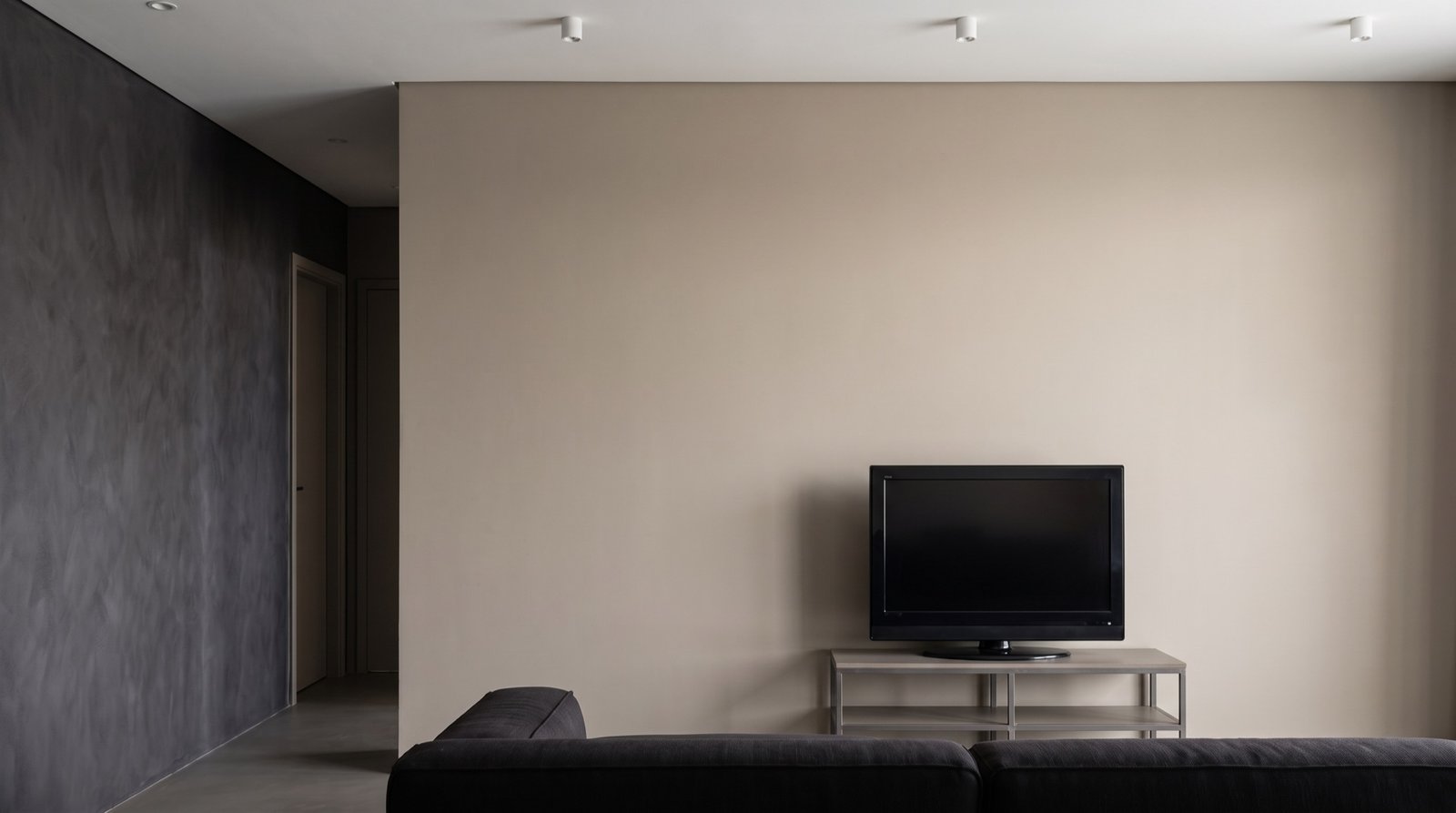 Living room before: plain painted drywall with a television on a low stand